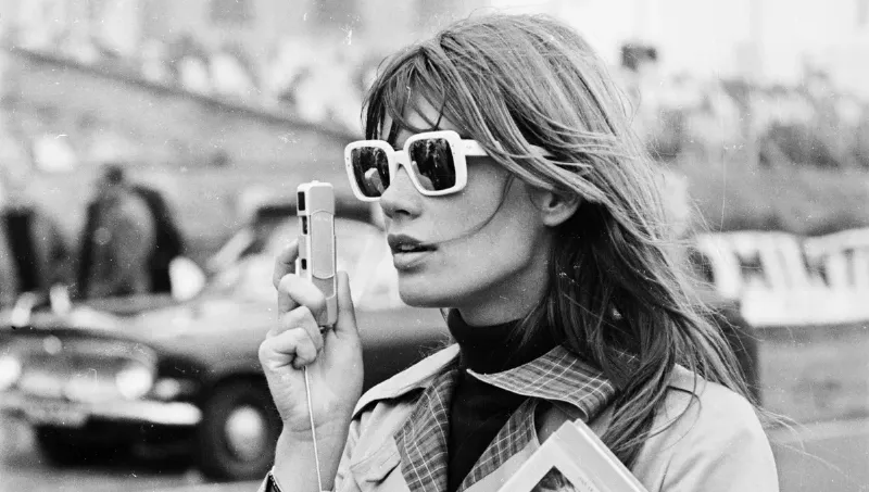 Une femme lisant un livre dans un café parisien élégant, symbolisant la culture et la beauté de l’art de vivre français